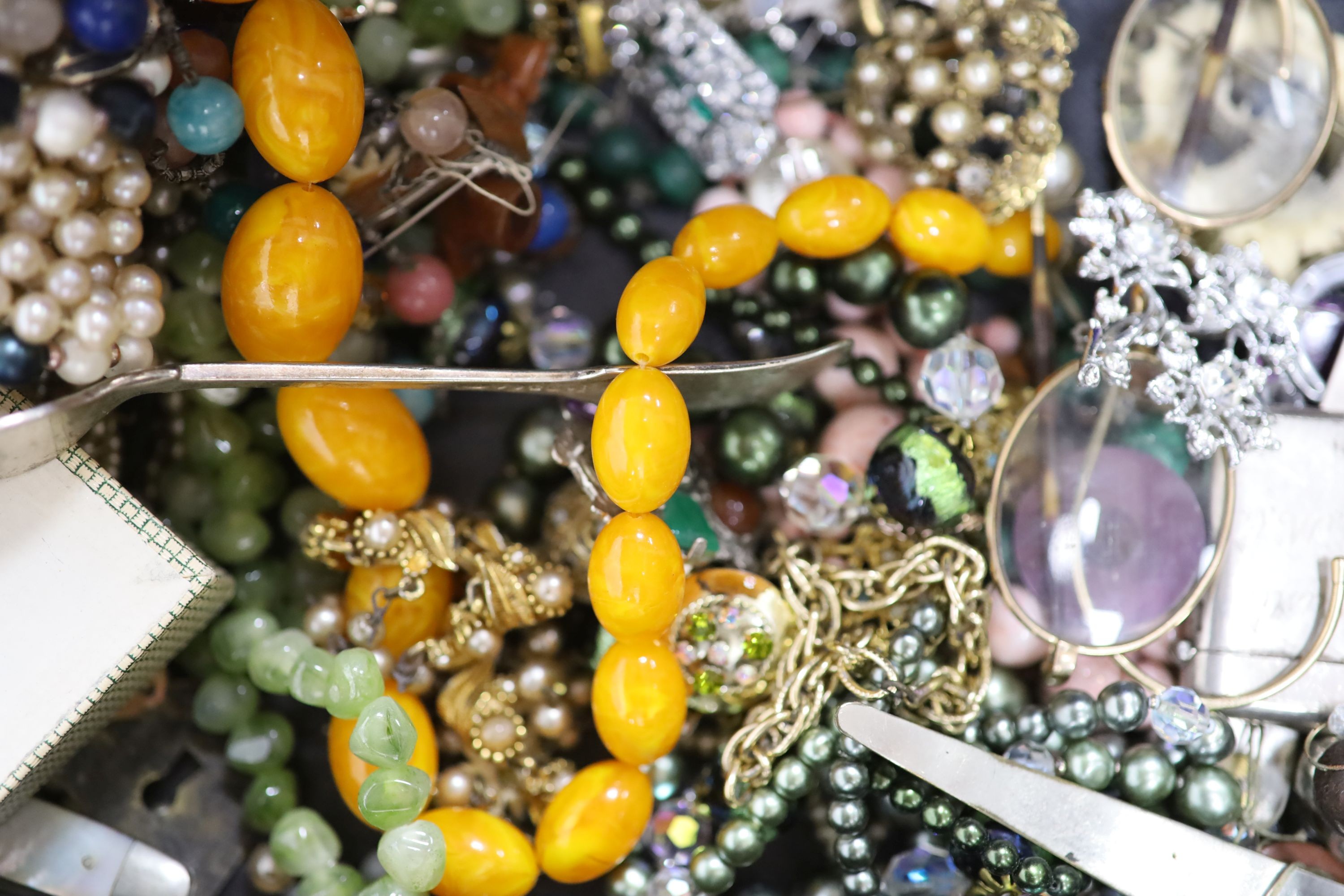 A quantity of assorted costume jewellery including a faux amber necklace etc.